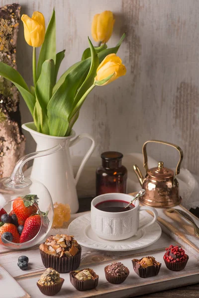 El zanaat çikolata tatlılar ve ahşap tepsi üzerinde beyaz Çin yaptı. Çay zamanı.