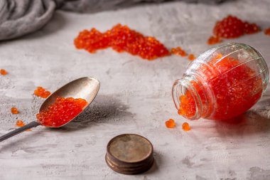 Gümüş kaşıkla cam kavanozda kırmızı havyar . Deniz ürünleri. Sağlıklı beslenme. Diyet. oncrete arka plan.