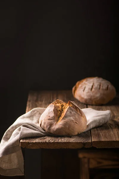 Ev yapımı ekmek ekşi hamur, ahşap masa üzerinde rustik pişmiş ekmek.