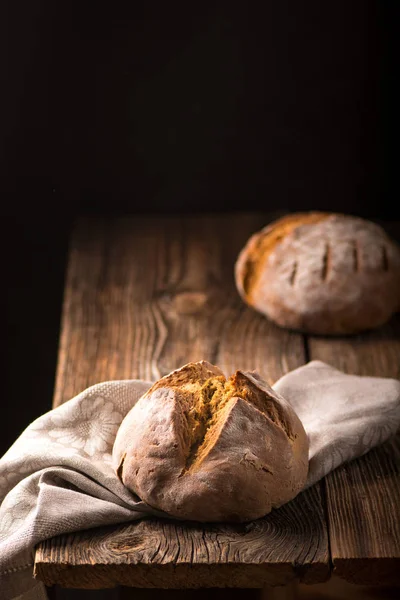 Ev yapımı ekmek ekşi hamur, ahşap masa üzerinde rustik pişmiş ekmek.