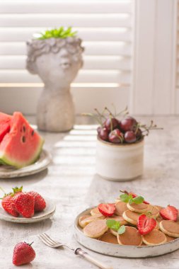 Küçük krepler ve beyaz masada çilekli şık ev kahvaltısı.. 