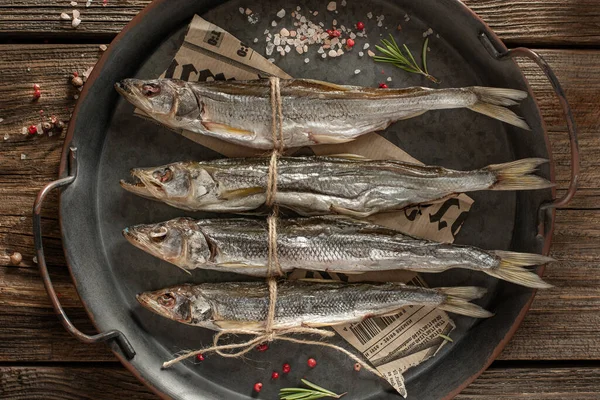 Güneşte kurutulmuş balık, ahşap zeminde tuzlanmış eritilmiş eritme. Bira için atıştırmalık kuru eritme.