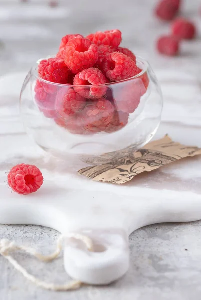 Mermer masadaki bardakta taze ahududu.