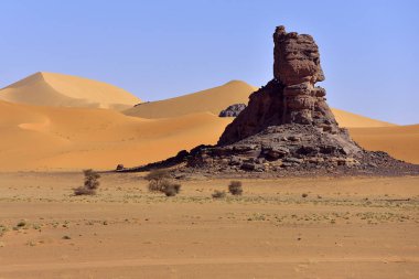 TADRART Parkı 'ndaki Algeria' daki Sahara çölünde. Kaya oluşumları, kum tepeleri ve çöl karaları.