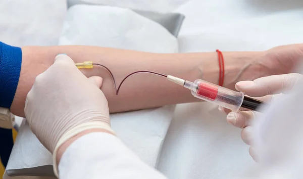 Doktor el kan örnekleme için kadın ven içine iğne yapışmasını yakın çekim