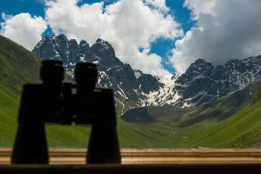Dağ manzaralı Pervazın üzerinde yalan büyük siyah dürbün.
