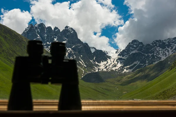 Dağ manzaralı Pervazın üzerinde yalan büyük siyah dürbün.