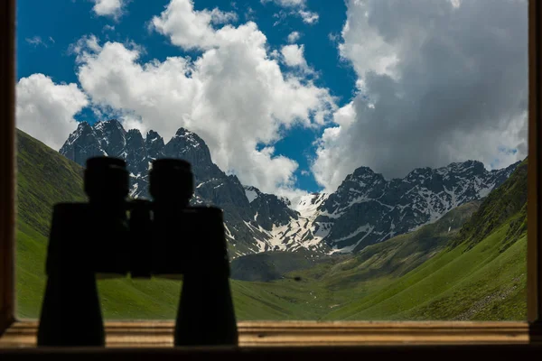 Dağ manzaralı Pervazın üzerinde yalan büyük siyah dürbün.