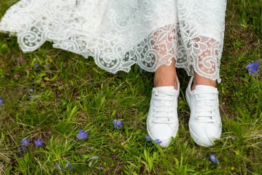 Yeşil zemin üzerine spor ayakkabı ayaklarda gelinin.