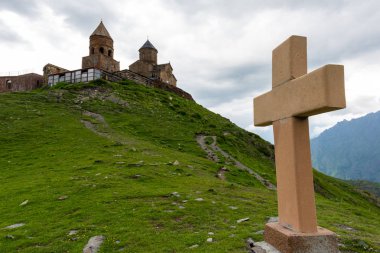 Bir piramit taş Gergeti Trinity Kilisesi Gürcistan yakınındaki Kazbek Dağı arka plan üzerinde çapraz
