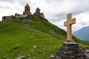 Bir piramit taş Gergeti Trinity Kilisesi Gürcistan yakınındaki Kazbek Dağı arka plan üzerinde çapraz