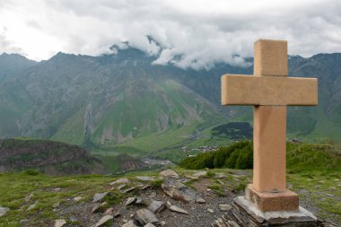 Bir piramit taş Georgi Gergeti Trinity Kilisesi yakınındaki Kazbek Dağı arka plan üzerinde çapraz