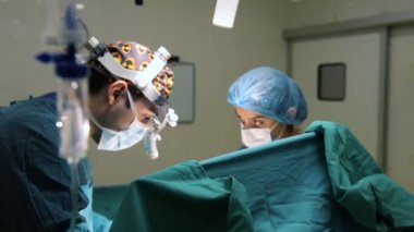 Cerrahi odasında çalışan intravenöz damamlı ve cerrahlar.
