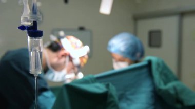 Cerrahi odasında çalışan intravenöz damamlı ve cerrahlar.