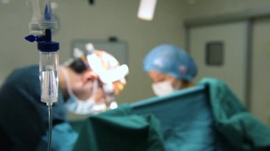 Cerrahi odasında çalışan intravenöz damamlı ve cerrahlar.