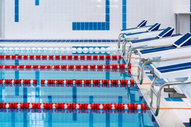 Kırmızı ve beyaz şeritli yüzme havuzu. Boş yüzme havuzu sessiz ayakta su ile insanlar olmadan. Kapalı havuzda su sporları.