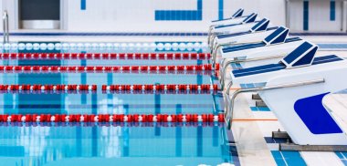 Kırmızı ve beyaz şeritli yüzme havuzu. Boş yüzme havuzu sessiz ayakta su ile insanlar olmadan. Kapalı havuzda su sporları.