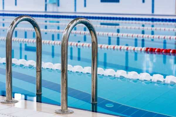 Kırmızı ve beyaz şeritli yüzme havuzu. Boş yüzme havuzu sessiz ayakta su ile insanlar olmadan. Kapalı havuzda su sporları.