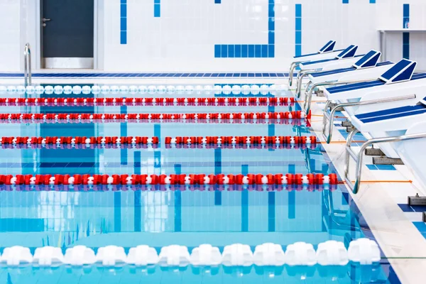 Kırmızı ve beyaz şeritli yüzme havuzu. Boş yüzme havuzu sessiz ayakta su ile insanlar olmadan. Kapalı havuzda su sporları.