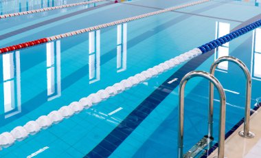 Kırmızı ve beyaz şeritli yüzme havuzu. Boş yüzme havuzu sessiz ayakta su ile insanlar olmadan. Kapalı havuzda su sporları.