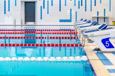 Kırmızı ve beyaz şeritli yüzme havuzu. Boş yüzme havuzu sessiz ayakta su ile insanlar olmadan. Kapalı havuzda su sporları.