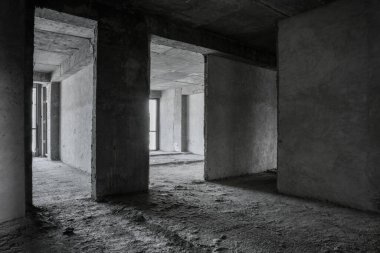 İçi tamamlanmamış bina. Apartmanda tamirat var. Geniş bir oda, pencerelerden gelen doğal ışıkla aydınlatılmış..