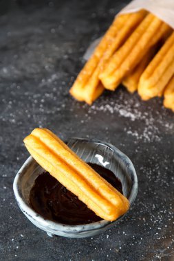 Geleneksel Meksika tatlı churro çikolata sos ile. Koyu arka plan