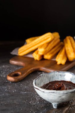 Geleneksel Meksika tatlı churro çikolata sos ile. Koyu arka plan