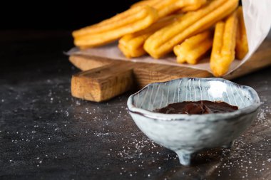 Geleneksel Meksika tatlı churro çikolata sos ile. Koyu arka plan