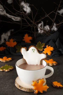Tatlı Cadılar Bayramı. Hayaletler, yaprakları ve kabaklar şeklinde kurabiye ile sıcak kakao. Koyu arka plan. Metin için yer