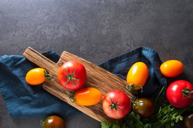 Kırmızı, sarı ve yeşil domates karışımı. İtalyan mutfağı. Koyu arka plan