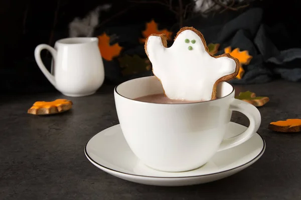 Sweet Halloween. Hot cocoa with cookies in the form of ghosts, leaves and pumpkins. Dark background. Space for text
