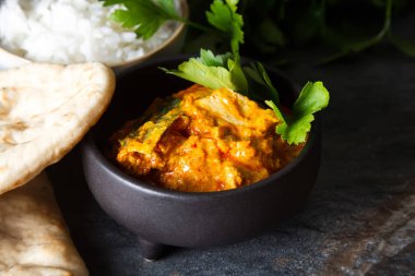 Tavuk tikka masala baharatlı Körili et gıda tereyağı tavuk pilav ve naan ekmek koyu arka plan yakın çekim. 