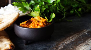 Tavuk tikka masala baharatlı Körili et gıda tereyağı tavuk pilav ve naan ekmek koyu arka plan yakın çekim. 