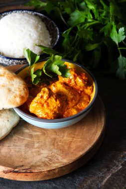 Tavuk tikka masala baharatlı Körili et gıda tereyağı tavuk pilav ve naan ekmek koyu arka plan yakın çekim. 