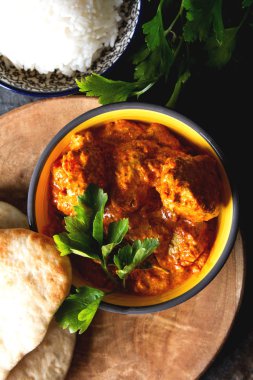 Tavuk tikka masala baharatlı Körili et gıda tereyağı tavuk pilav ve naan ekmek koyu arka plan yakın çekim. 
