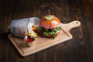 Burger karides ve biftek, patates kızartması ve sos. Fast food. Koyu ahşap arka plan