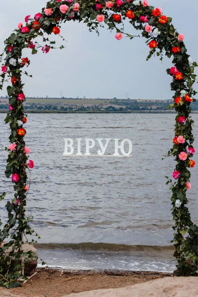 Sahilde çiçeklerden yapılmış bir kemer duruyor. 