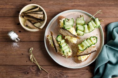 Sprats, yumurta ve salatalık ile Bruschetta