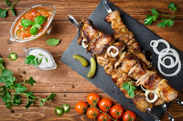 Varkens Spiesjes met uien op een houten tafel — Stockfoto