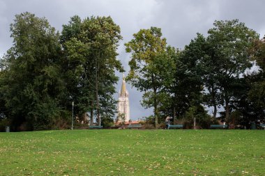 BRUGES, BELGIUM - 5 EKİM 2019: Merkezinde çan kulesi olan güzel bir şehir parkı