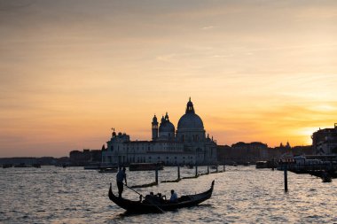 Santa Maria della Salute 'un tarihi Bazilikası ile ünlü Büyük Kanal' daki geleneksel gondolların muhteşem manzarası Venedik 'te gün batımında romantik altın gece ışığı altında