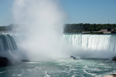 Çekici tekneyle Niagara Şelalesi turu. Turistler Niagara At Nalı 'nın yakınındaki gezi teknesinde güneşli yaz gününde yelken açıyorlar..