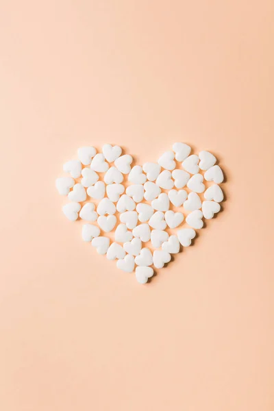 Píldoras en forma de corazón sobre un fondo beige . — Foto de Stock