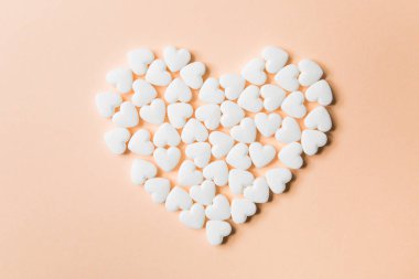 Hapları bej renkli arka plan üzerinde kalp şeklinde.