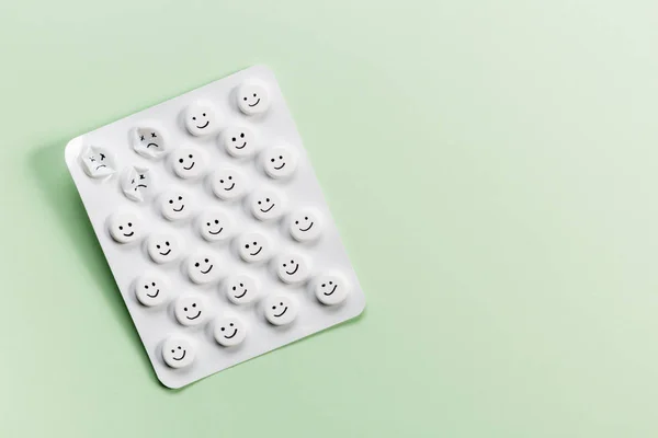 Embalagem de comprimidos com comprimidos brancos sobre um fundo verde com espaço livre . — Fotografia de Stock