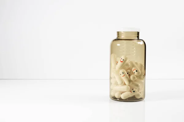Botella de vidrio con divertidas emociones pintadas en las cápsulas . — Foto de Stock