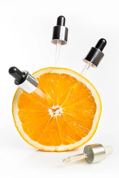 Vitamina C en forma de suero en pipetas, tomada de una naranja para la piel joven . — Foto de Stock