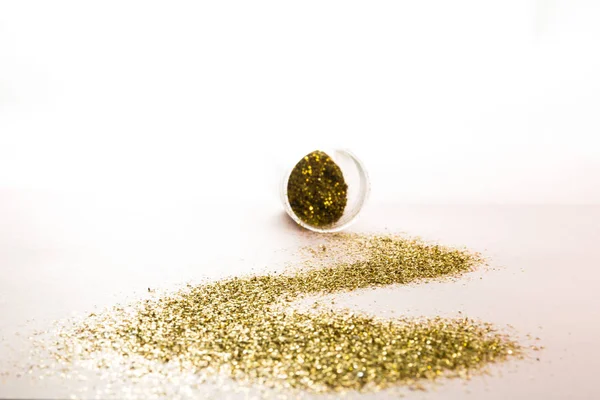 A jar with a track of scattered gold spangles. — Stock Photo, Image