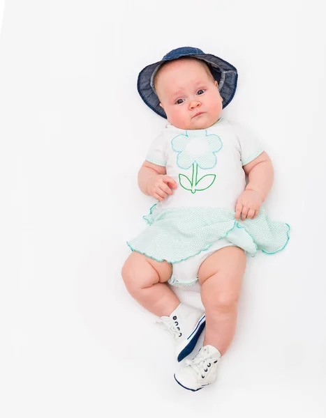 Feliz lindo bebé sonriente de 4 meses en jeans sombrero sobre un fondo blanco . — Foto de Stock